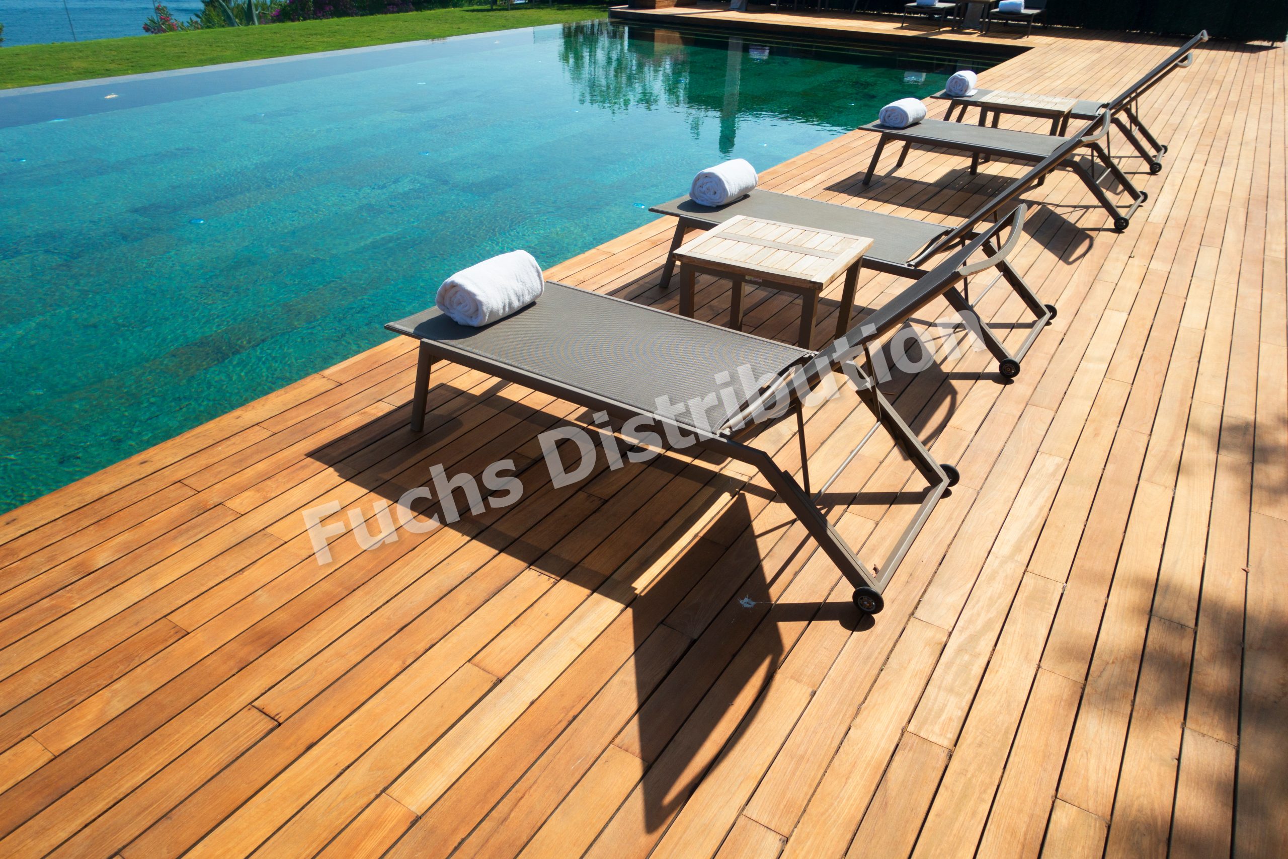 Deck chairs on Wooden plank floor against swimming pool