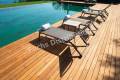 Deck chairs on Wooden plank floor against swimming pool